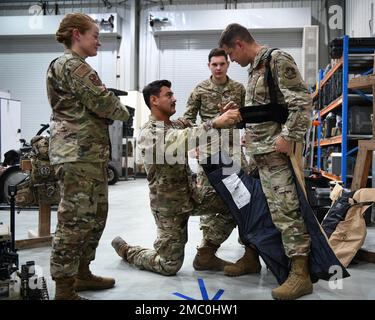 Staff Sgt. Raul “Adrian” Ayala, an Explosive Ordinance Disposal technician assigned to the 380th Expeditionary Civil Engineer Squadron, assists Brig. Gen. David Lopez, the commander of the 380th Air Expeditionary Wing, with donning an advanced bomb suit during an immersion event June 23, 2022, at Al Dhafra Air Base, United Arab Emirates. The 380th ECES mission is to operate and maintain ADAB while providing emergency services support 24/7. Stock Photo