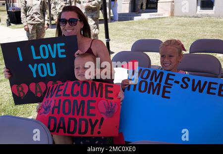 The family of Capt. Gabriel Egas, G35, 1st Theater Sustainment Command show their handmade signs of support for him at the redeployment ceremony for Soldiers and civilians who returned from a six-month deployment, June 23, 2022, at Fort Knox, Kentucky. Stock Photo