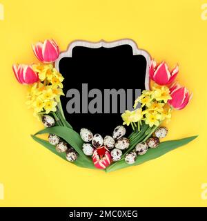 Happy Easter Spring abstract background border with tulip and narcissus flowers, quail eggs with chalkboard copy space. Creative floral layout. Stock Photo