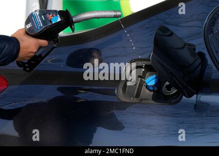 A man takes a petrol nozzle off his car after adding fuel at a petrol station in London, Tuesday, March 8, 2022. Prices for petrol and diesel reached new highs due to Russia's war in Ukraine.(AP Photo/Frank Augstein)