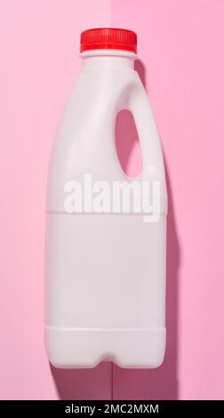 White plastic bottle for milk and dairy products on a pink background Stock Photo