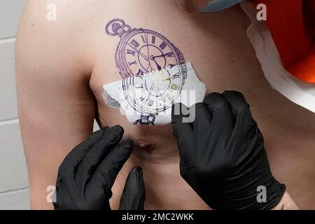 Premium Photo | Hand of tattooist in rubber gloves drawing a tattoo with electric  tattoo gun closeup