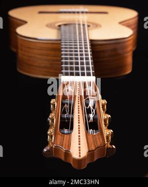 Classical guitar headstock detail isolated on black background. Classic acoustic guitar concept. Perfect for flyer, card, poster or wallpaper Stock Photo
