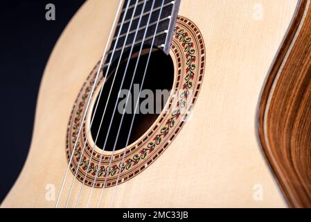 Classical guitar top isolated on black background with a beautiful mosaic rosette, view from the top side. Beautiful Brazilian wood - Pau Ferro Stock Photo