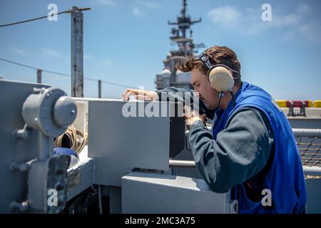 PACIFIC OCEAN (June 24, 2022) Aviation Boatswain’s Mate Airman Orion Burnett, a native of Charlotte, Florida, assigned to the amphibious assault ship USS Boxer (LHD 4), coordinates with flight deck control as the ship conducts elevator operations on the flight deck during the ship’s first underway in more than two years after completing a planned maintenance availability. Boxer is a Wasp-class amphibious assault ship homeported in San Diego. Stock Photo