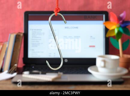 data phishing, big hook on laptop computer showing fictional phishing website, blurred in the background Stock Photo