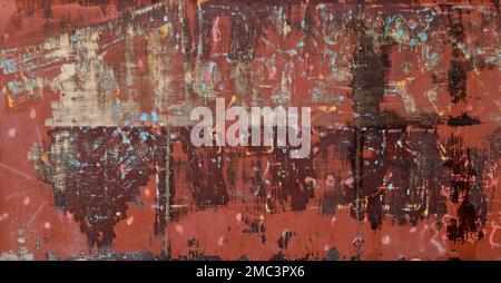 Front view of a messy, dirty and weathered plywood wall painted in red with stains from graffiti removal. Abstract full frame textured background. Stock Photo