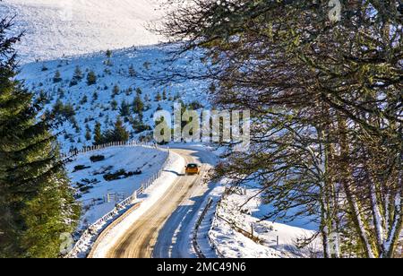Tomintoul Moray Scotland Glenlivet Estate car on the bends the old Military Road A 939 in winter and snow covered hills Stock Photo