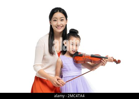 The female teacher guide girl playing Musical Instruments Stock Photo