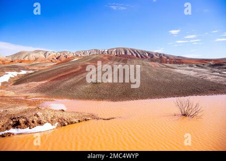 Red reservoir in red striped mountains. Khizi region. Azerbaijan. Stock Photo