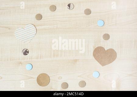 Round frame of craft paper hearts and circles on wooden background. Valentine's day mockup. Stock Photo