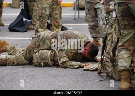 A Soldier collapses in exhaustion over his ruck sack after crossing the finish line at the 210 Field Artillery Brigade, 2d Infantry Division/ROK-U.S. Combined Division Army Heritage 10-kilometer Ruck March on Camp Casey, June 25, 2022. The demanding course took Soldiers around the Camp Casey and Camp Hovey footprint as well as up the hills located off-post, to the East of the base. (US Army photos by Staff Sgt. Felix Mena, 210 FAB PAO) Stock Photo