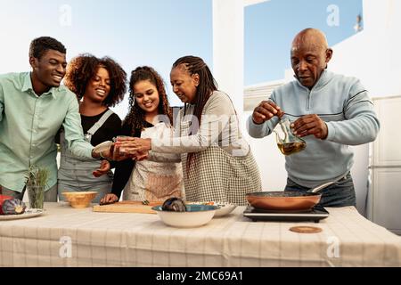 Happy African family preparing a dinner together on house patio Stock Photo