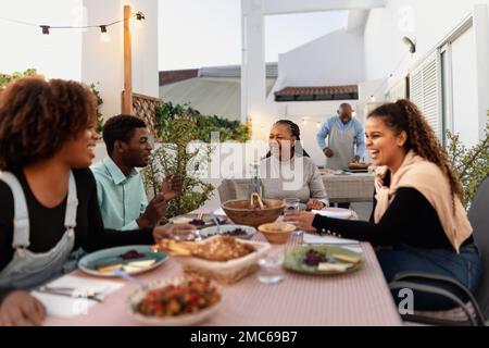 Happy African family dining together on house patio Stock Photo