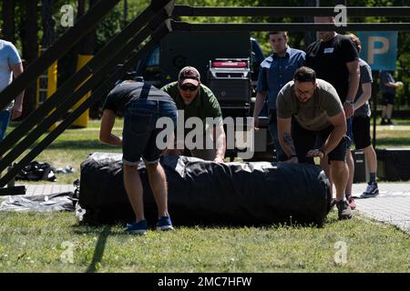 U.S. Air Force Senior Master Sgt. Brent Kenney, 52nd Civil Engineer Squadron Heavy Repair superintendent (center), leads volunteers in setting up the Project Arcwater system in Otwock, Poland, June 26, 2022. Arcwater can fully supply a tent with power, running televisions, an air conditioning system and more primarily using solar power. Arcwater,Energy,Humanitarian,INNOVATION,Spark Tank,solar, Stock Photo