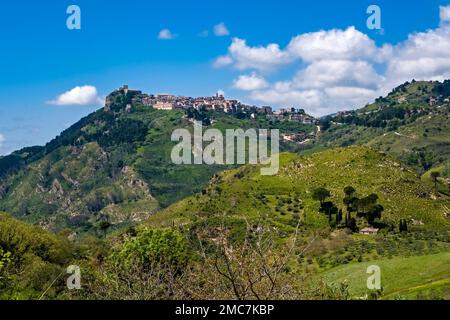 Agricultural landscape with green hills, trees and fields in Central Sicily, the small town of Giuliana located on top of a hill. Stock Photo