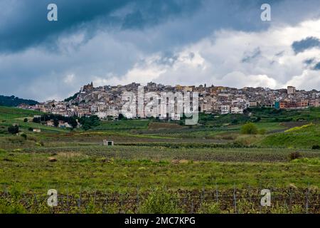 Agricultural landscape with green hills, vineyards and fields in Central Sicily, the small town of Sambuca di Sicilia located on top of a hill. Stock Photo