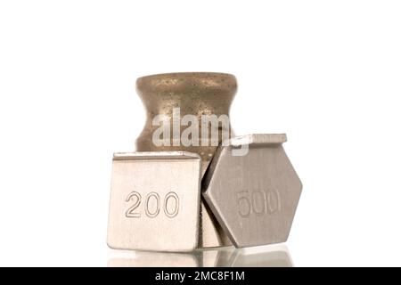 Three metal weights for old jewelry scales, macro, isolated on white background. Stock Photo