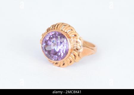 Angled close up of a ring with a large and rare Alexandrite stone in a gold frame Stock Photo