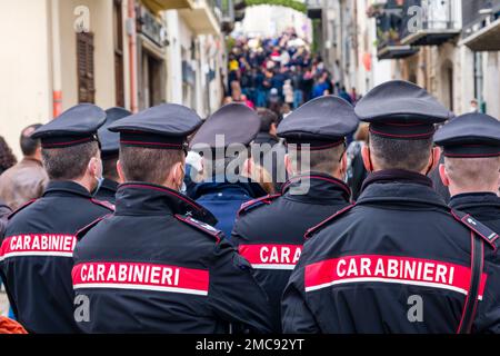 A group of police officers, carabinieri, observe the Easter procession in the small town of Prizzi. Stock Photo