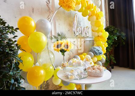 Party decorated with balloons. Photozone from yellow and green balloons. Birthday celebrations, wedding, engagement, baby shower. Stock Photo