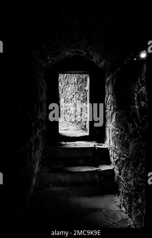 Dungeons of a medieval castle. Passage in the fortress wall. Black and ...