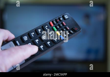 TV remote in use and held by a person Stock Photo