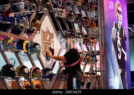 A worker cleans a league logo inside the NFL Experience, an