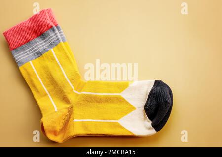 A pair of striped socks. Yellow socks on a beige background. Stock Photo