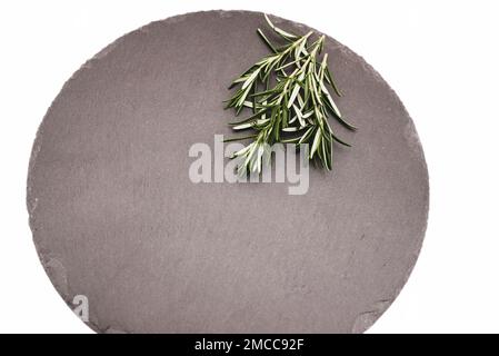 Fresh green rosemary twigs on a black stone plate. food herbal concept organic Stock Photo