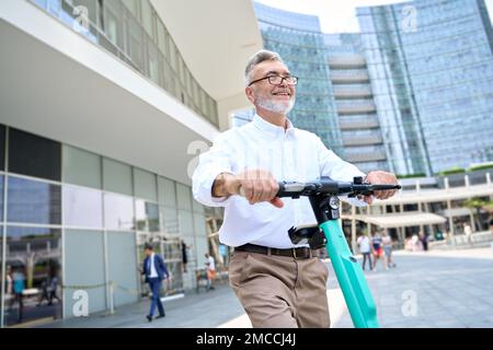 Happy older man using mobile app for bike rental renting bike in city park. Stock Photo
