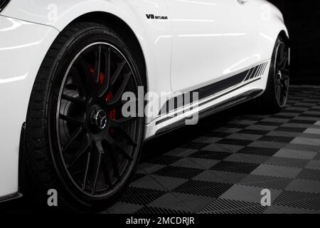 The Rear Gloss Black Alloy Wheel On A 2016 Mercedes Benz C63s AMG W205 Edition 1 In White With Black AMG Side Stripes Stock Photo