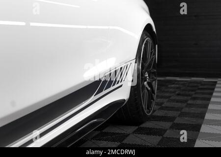 The Rear Gloss Black Alloy Wheel On A 2016 Mercedes Benz C63s AMG W205 Edition 1 In White With Black AMG Side Stripes Stock Photo