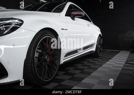 The Rear Gloss Black Alloy Wheel On A 2016 Mercedes Benz C63s AMG W205 Edition 1 In White With Black AMG Side Stripes Stock Photo