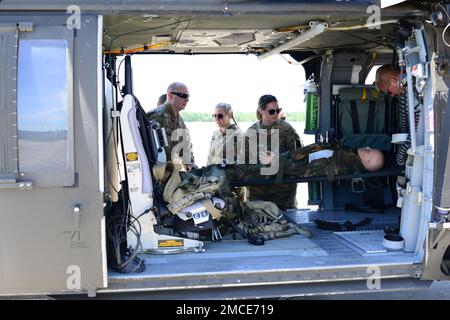 Airmen with the Maine Air National Guard’s 101st Air Refueling Wing’s (101 ARW) Medical Group and soldiers with the Maine Army National Guard’s 126th Aviation Regiment participated in a joint casualty evacuation training exercise, Bangor, ME JUN 29, 2022. During the exercise both airman and soldiers successfully secured and hoisted a simulated casualty multiple times through a side cargo door of a 101 ARW KC-135R before completing a continuous run-through starting with casualty movement from a 126th UH-60 Blackhawk to securing the casualty in a 101 ARW KC-135R aircraft. Stock Photo