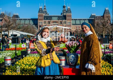 Two women dressing like two characters from the paints of Johannes Vermeer paintings are seen posing for the media. Each year on the 3rd Saturday of January, the National Tulip Day is celebrated in Amsterdam. Dutch tulip growers built a huge picking garden with more than 200,000 colorful tulips at the Museumplein in Amsterdam. Visitors are allowed to pick tulips for free. The event was opened by Olympic skating champion, Irene Schouten. Prior to the opening, she christened a new tulip: Tulipa 'Dutch Pearl' as a reference to the world - famous painting 'The girl with a pearl earring' by Johanne Stock Photo