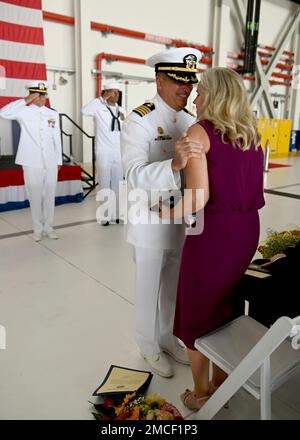 220630-N-OX321-2708 NAVAL AIR STATION SIGONELLA, Italy (June 30, 2022) – Capt. Timothy Thompson embraces his wife, Amy, after handing her his retirement flag during his retirement ceremony held at the conclusion of the Commander, Task Force 67 change of command where he was relieved by Capt. Bryan Hagar as the Commodore for CTF 67. Thompson retires after having served 37 years in the United States Navy. Stock Photo