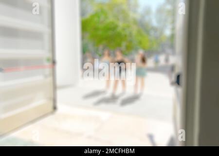 Blurred image of people walking through the door of a building to view an art exhibition in a gallery. Stock Photo