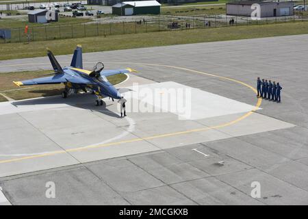 U.S. Navy and Marine Corps Blue Angels members stand at parade rest in front of the hangar at Coast Guard Air Station Traverse City, Michigan, July 1, 2022. The Blue Angels practiced their performance before performing at the airshow for the National Cherry Festival. Stock Photo