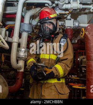 PHILIPPINE SEA (July 2, 2022) Gas Turbine Systems Technician (Mechanical) 2nd Class Andrew Youngstrom, from Hastings, Minnesota, simulates putting out a fire during a firefighting drill aboard Arleigh Burke-class guided-missile destroyer USS Dewey (DDG 105). Dewey is assigned to Task Force 71/Destroyer Squadron (DESRON) 15, the Navy’s largest forward-deployed DESRON and the U.S. 7th fleet’s principal surface force. Stock Photo