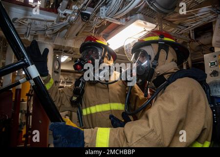 PHILIPPINE SEA (July 2, 2022) Cryptologic Technician (Technical) Denzel Hood, left, from Jersey City, New Jersey, and Gas Turbine Systems Technician (Mechanical) 2nd Class Andrew Youngstrom, from Hastings, Minnesota, relay information to a messenger during a firefighting drill aboard Arleigh Burke-class guided-missile destroyer USS Dewey (DDG 105). Dewey is assigned to Task Force 71/Destroyer Squadron (DESRON) 15, the Navy’s largest forward-deployed DESRON and the U.S. 7th fleet’s principal surface force. Stock Photo