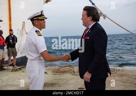 VUNG RO BAY, Vietnam (July 3rd, 2022) – Mr. Marc Knapper, U.S. Ambassador to Vietnam, right, shakes hands with Captain Hank Kim, Pacific Partnership 2022 (PP22) mission commander, upon arrival aboard Military Sealift Command hospital ship USNS Mercy (T-AH 19) during the PP22 Vietnam closing ceremony. Now in its 17th year, Pacific Partnership is the largest annual multinational humanitarian assistance and disaster relief preparedness mission conducted in the Indo-Pacific. Stock Photo