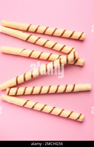 Tasty wafer rolls on pink background Stock Photo