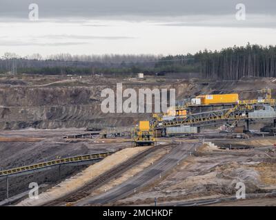 Containers and steel constructions in an open pit mine. The exploitation of brown coal destroyed the natural environment. Transformed landscape Stock Photo