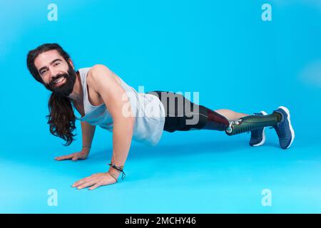 Smiley man with a prosthetic leg doing push-ups Stock Photo