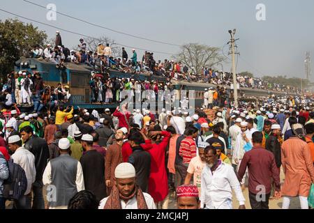 Dhaka, Bangladesh. 22nd Jan, 2023. Muslim devotees travel by overcrowded risky trains after attending the Akheri Munajat or final prayers, at the Biswa Ijtema in Tongi, Dhaka, Bangladesh. Locals tackle the journey climbing on, clinging to and clambering along the roofs of locomotives. With no seats available inside, many commuters decide to take the risk and choose a rooftop view for their journey out of Dhaka city. Credit: Joy Saha/Alamy Live News Stock Photo