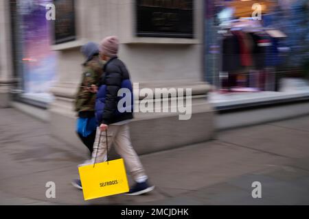 A man carries a Selfridges bag after leaving the department store