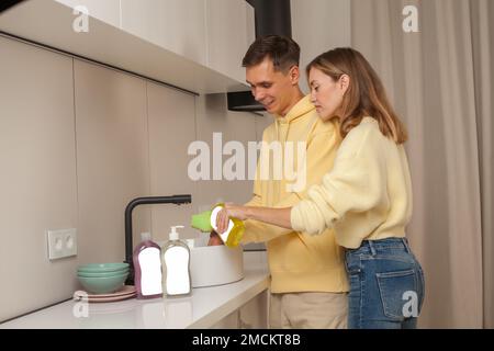 Couple washing the dishes using dishwashing liquid with blank label Stock Photo