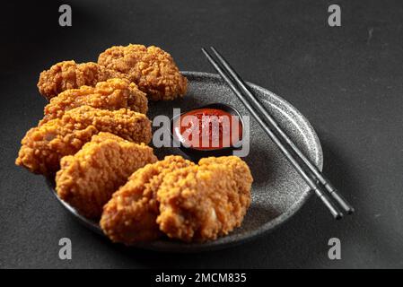 Asian meat deep-fried, breaded in oil in a plate on a dark stone background with copy space. Top view, flat plan Stock Photo