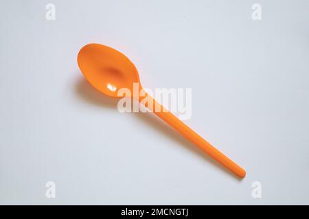 plastic orange spoon on white background, spoon Stock Photo